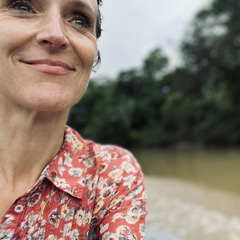 face smiling with vegetation in background