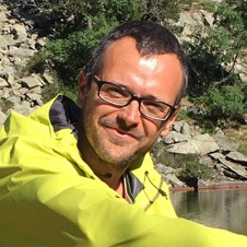 half-smile, wearing bright yellow coat