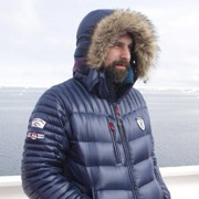 person wearing hood in icy and watery environs